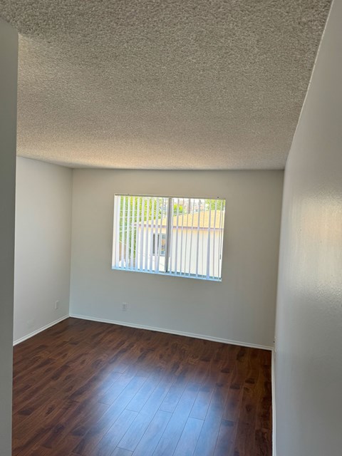 A room with a window and wooden floors.